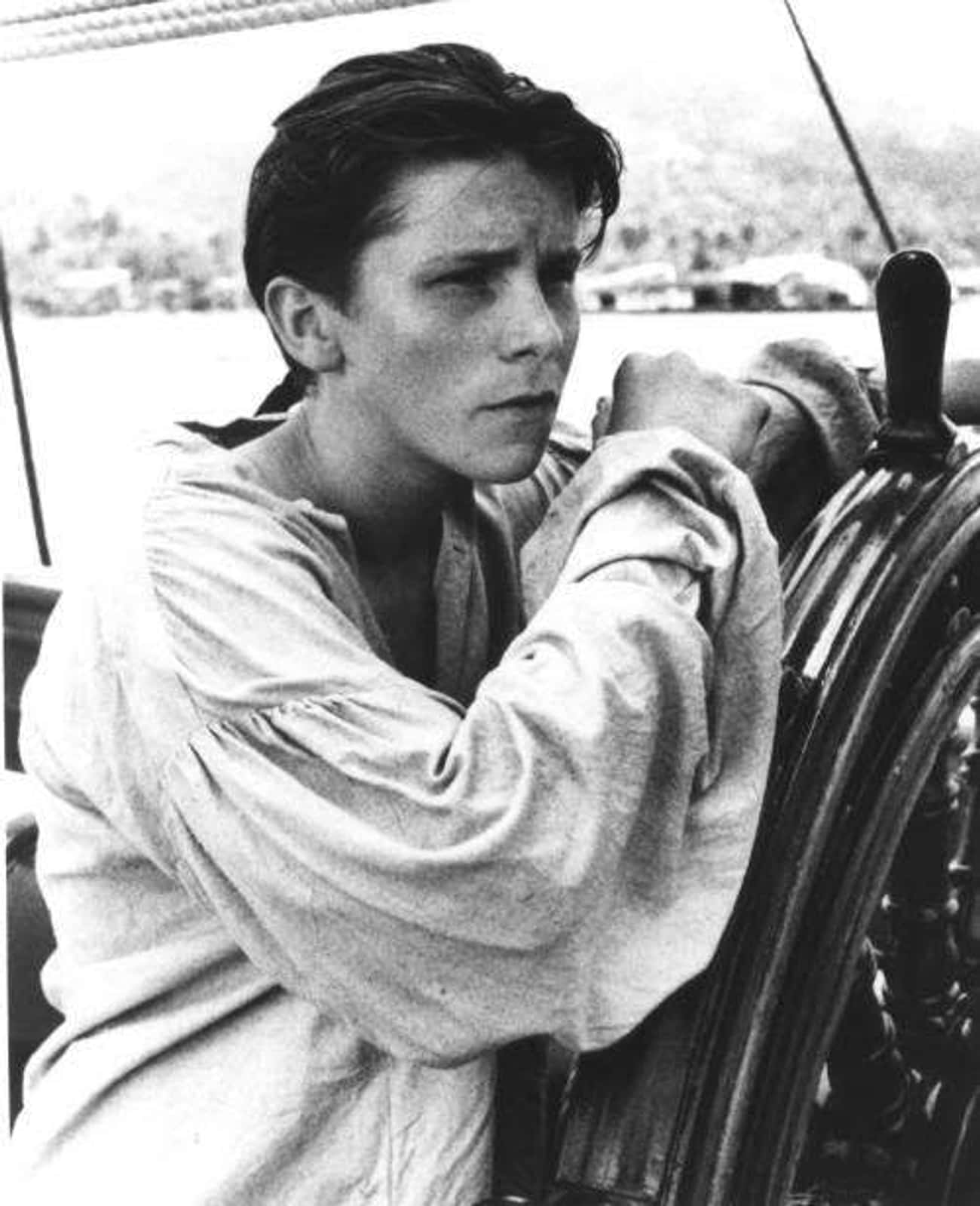 Young Christian Bale in White Blouse Steering Ship