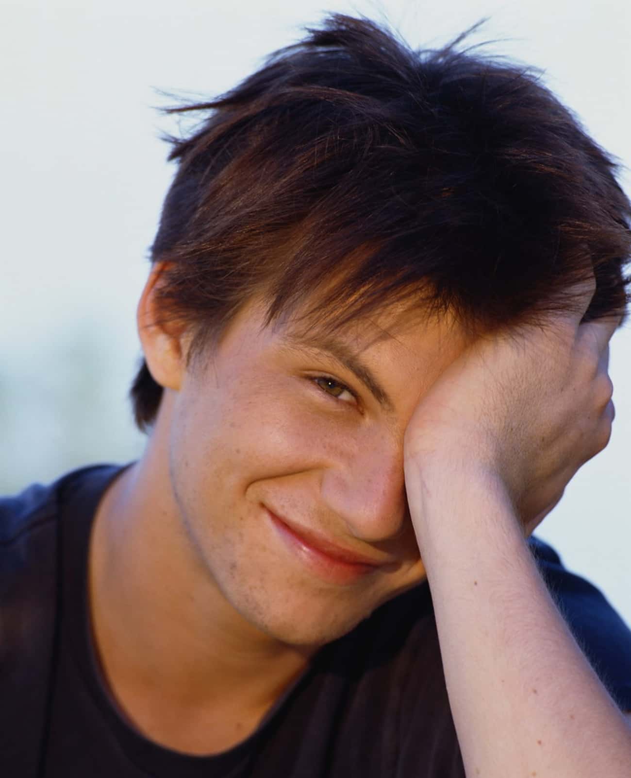 Young Christian Slater in Black T-Shirt Leaning on Hand