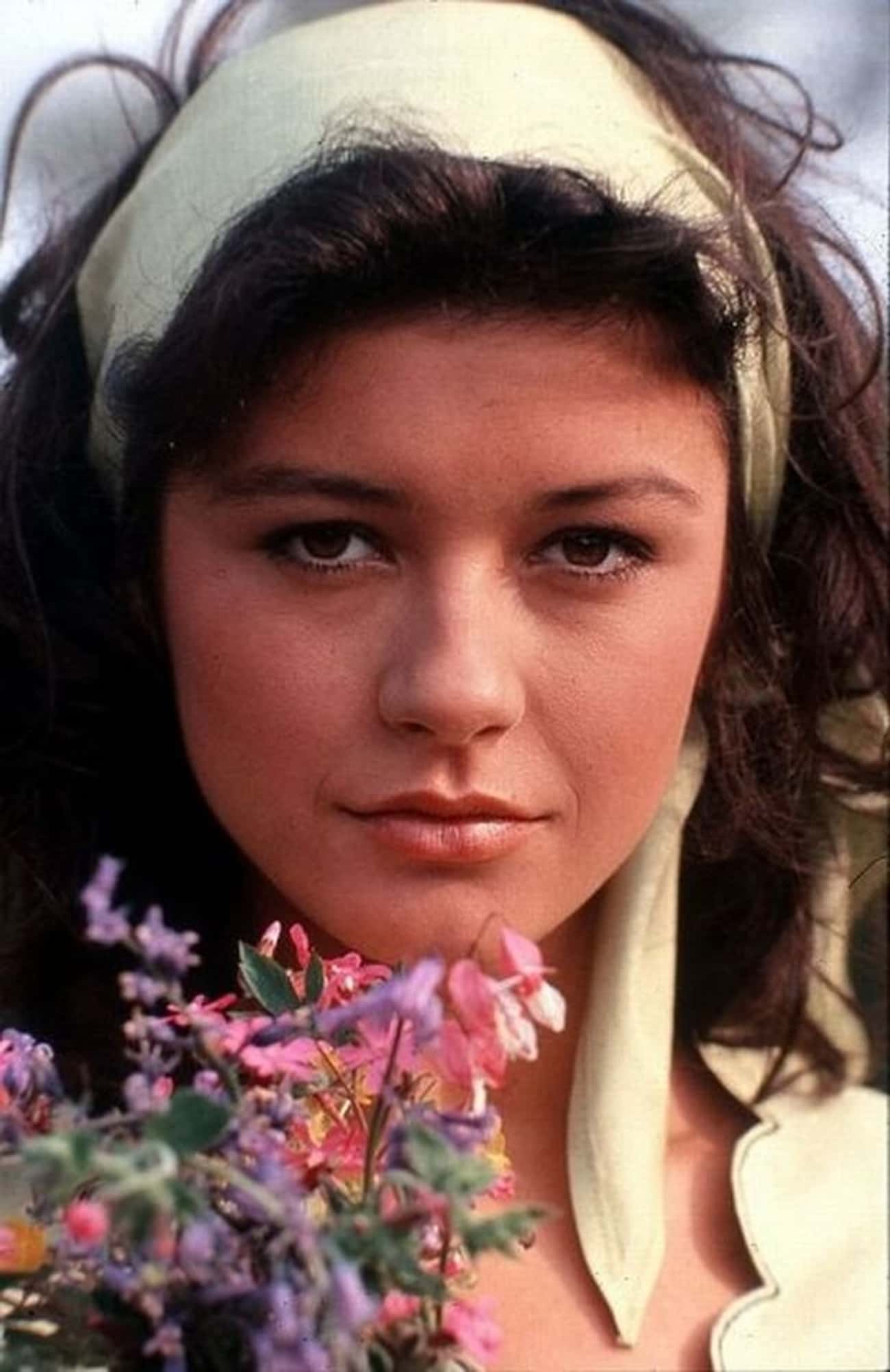Young Catherine Zeta-Jones in White Blouse Holding Flowers