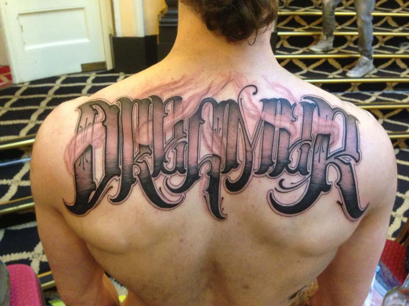 Lettering Tattoo On Upper Back