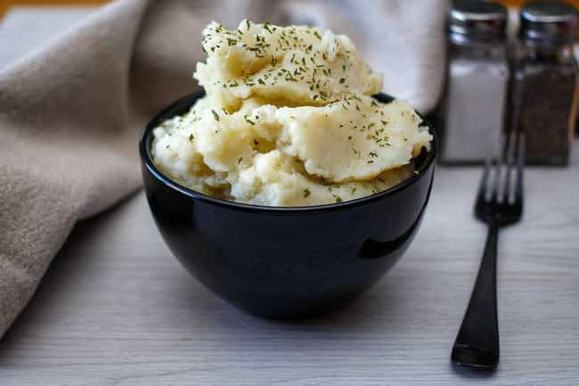 Mother feeds newborn mashed potatoes