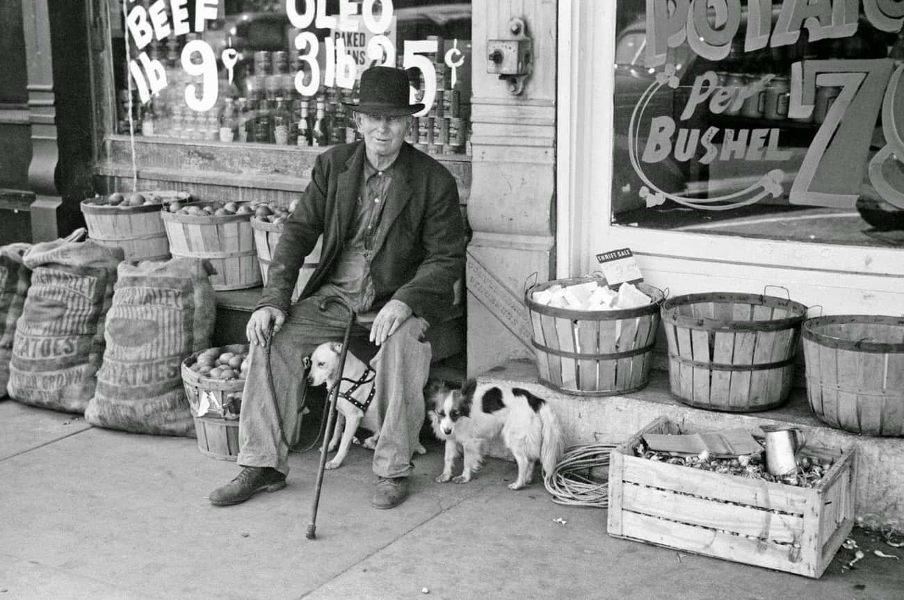 Man And Dogs In Front Of Grocery Store, Robinson, Illinois, 1940