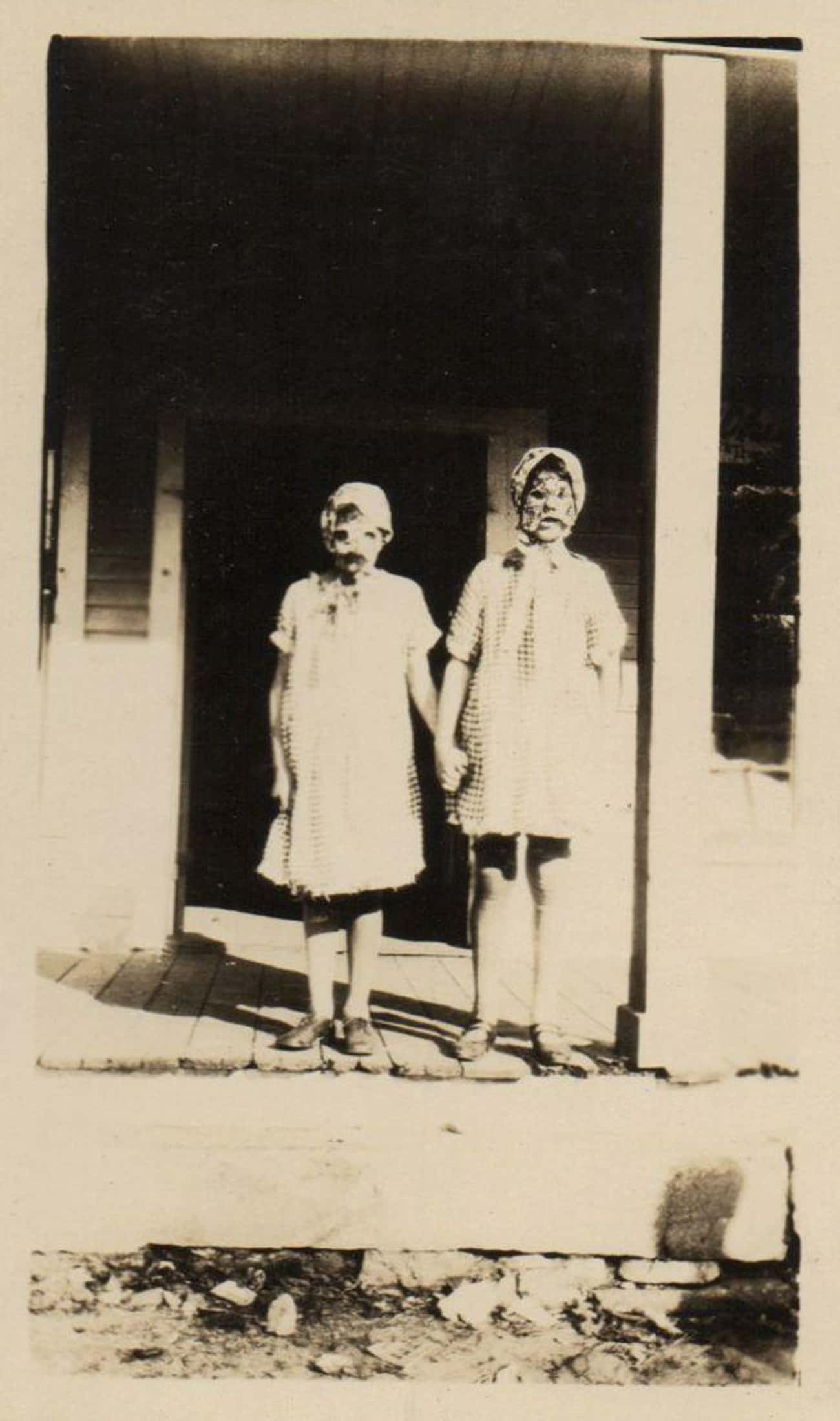 Two Girls In Halloween Masks On A Porch