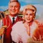 Eddie Albert, Eva Gabor, Tom Lester   Green Acres is an American sitcom starring Eddie Albert and Eva Gabor as a couple who move from New York City to a rural country farm.